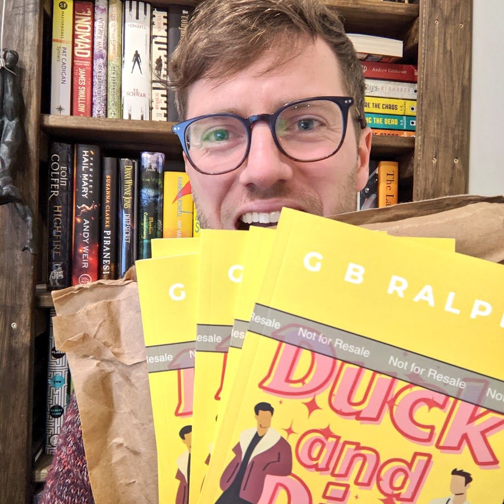 Author holding up Duck and Dive paperback book proof copies