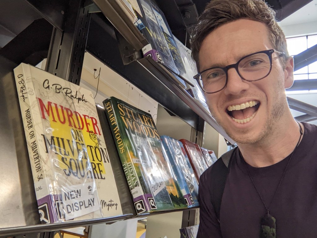 Murder on Milverton Square (A Milverton Mystery) by G B Ralph. Paperback book on local library New Books shelf. Photo with author.