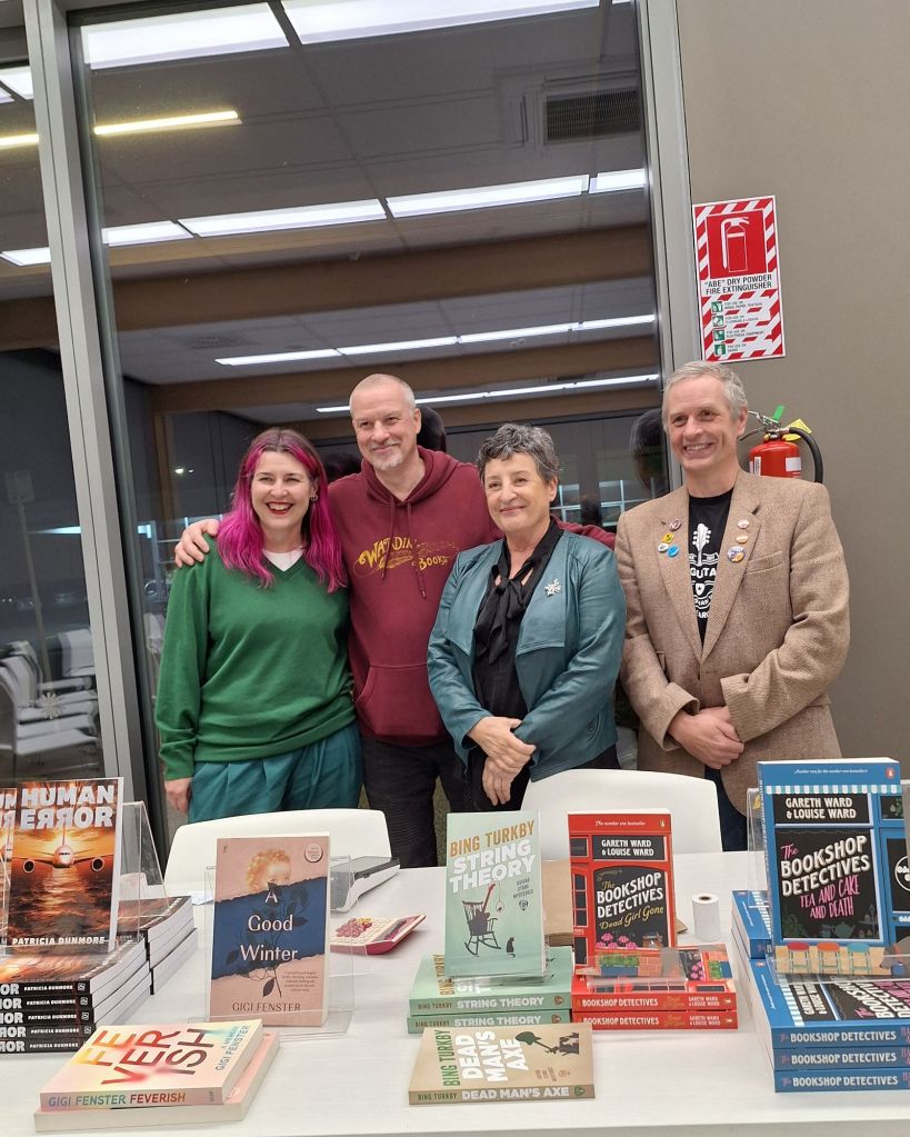 Four authors standing behind a table displaying their books