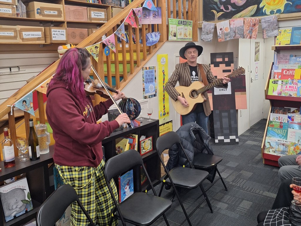 Two authors giving a musical performance in a bookshop