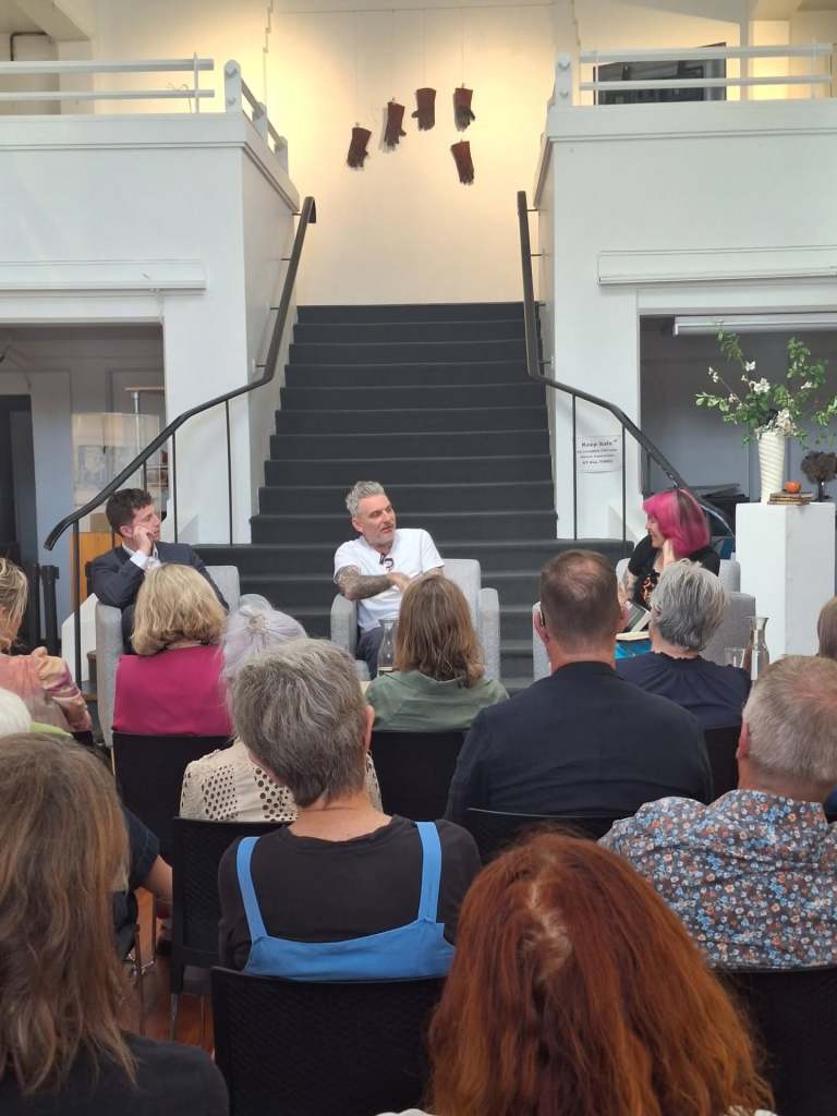 Two panellists and a chairperson on stage