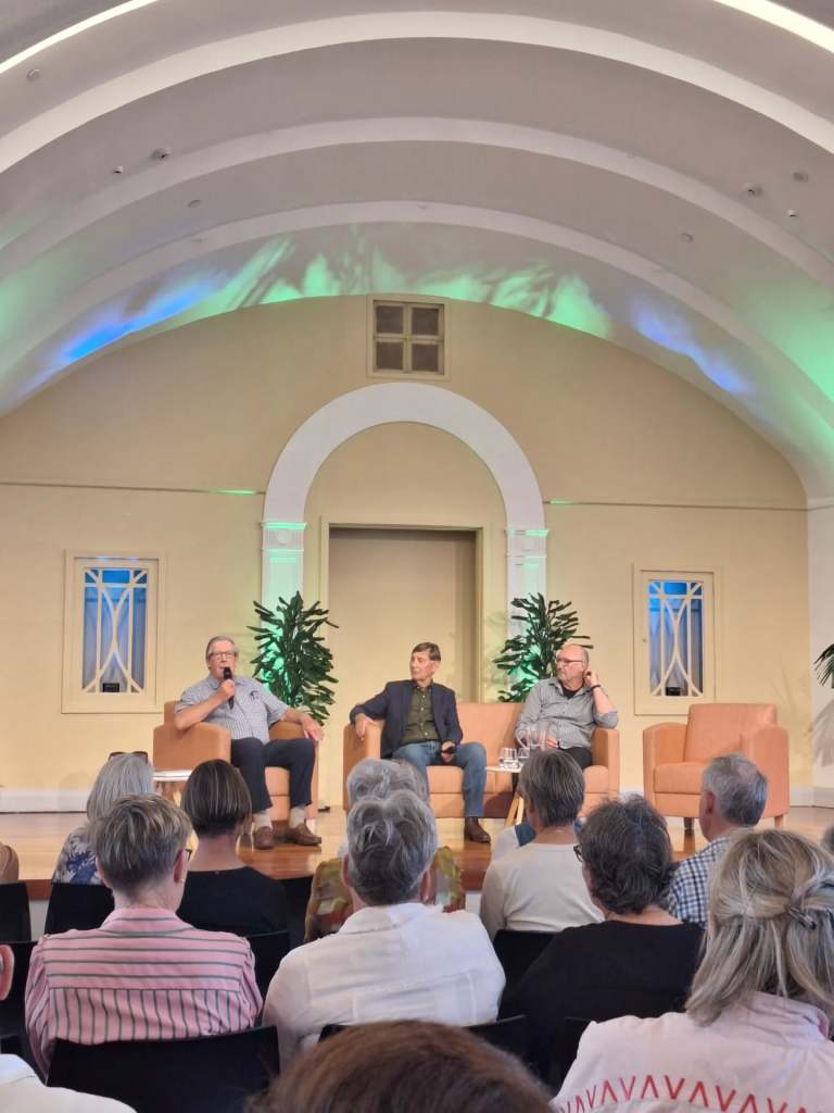 Two panellists and a chairperson on stage