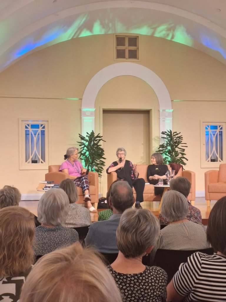 Two panellists and a chairperson on stage