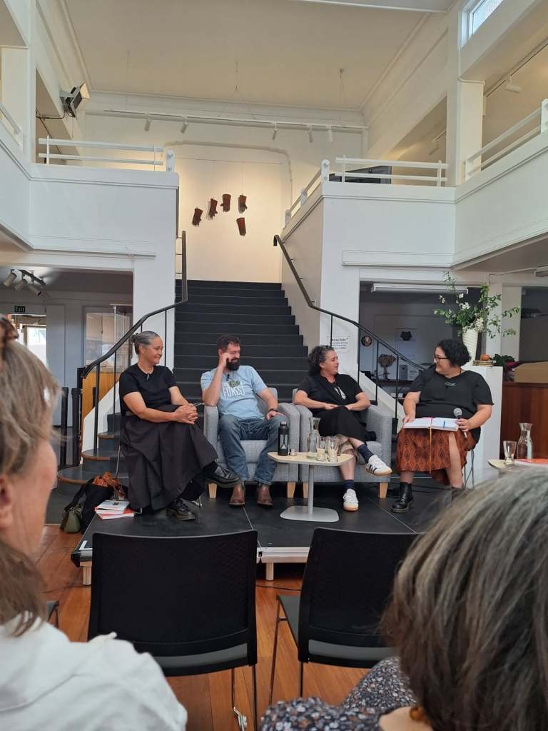 Three panellists and a chairperson on stage