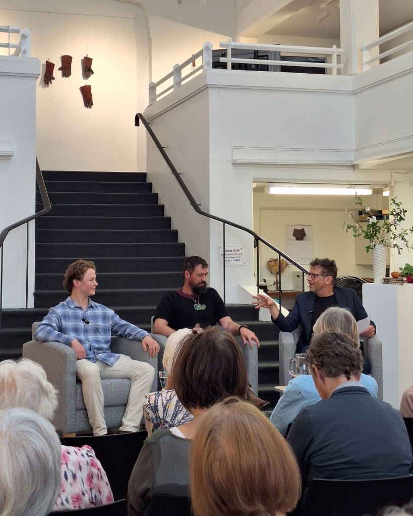 Two panellists and a chairperson on stage