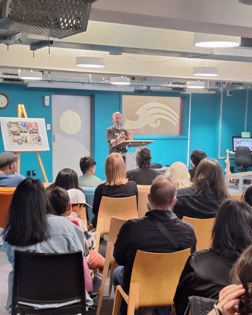Sean Monaghan at a lectern speaking to readers